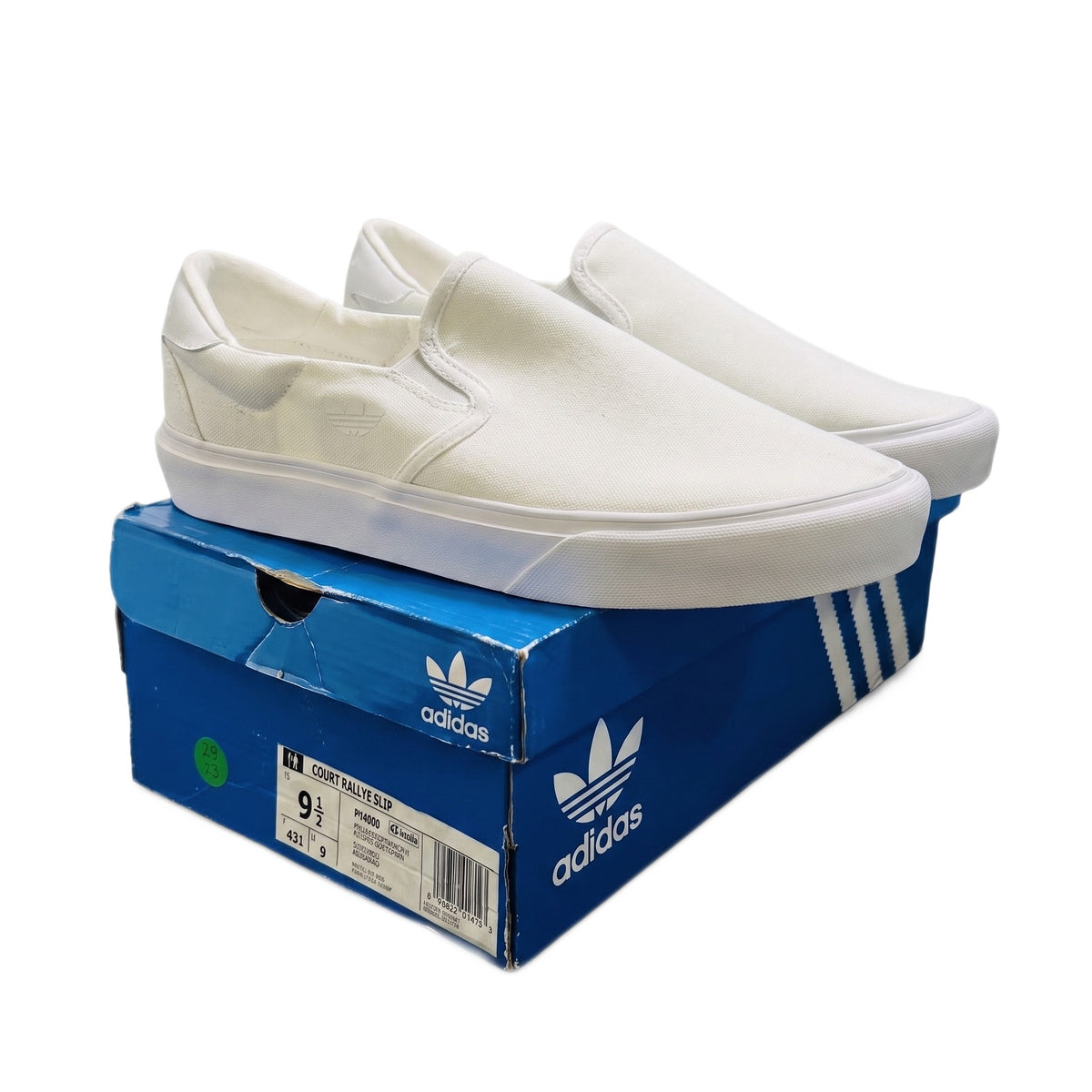 Three-quarter view of both white sneakers sitting on top of a damaged blue shoe box.