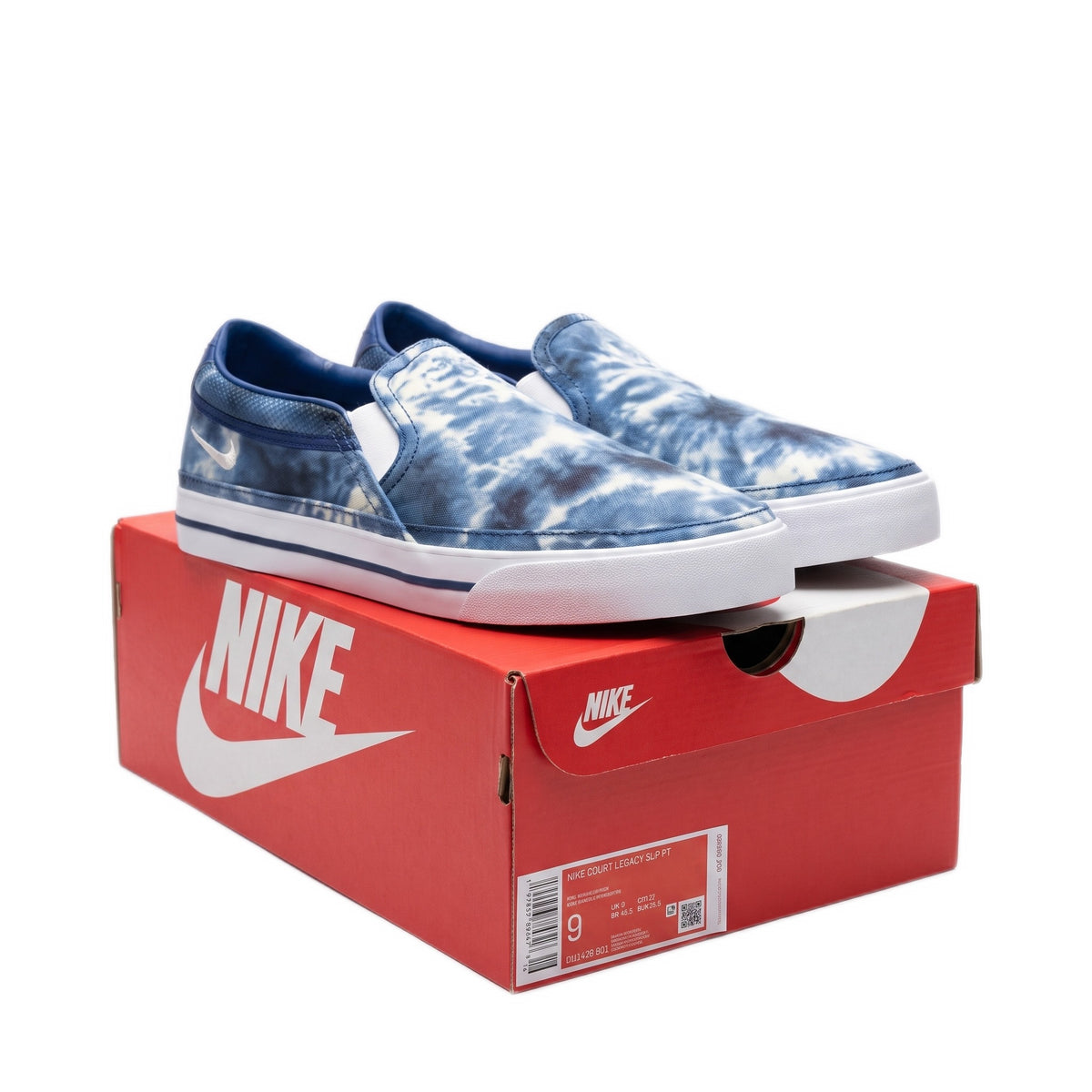 Three-quarter view of both tie-dye slip-on shoes on top of their red shoe box.