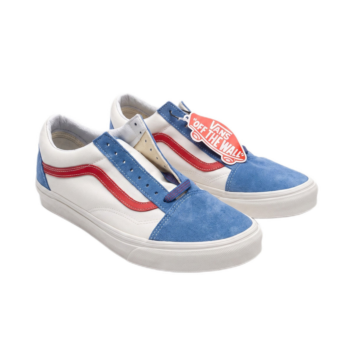 Three-quarter view of white canvas sneakers with blue suede panels and red stripes.