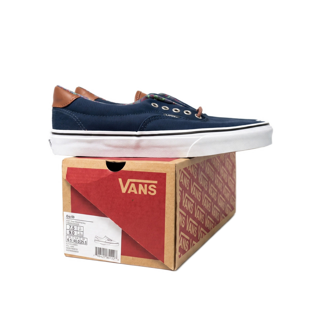 Side profile of one navy shoe resting on its cardboard shoe box.