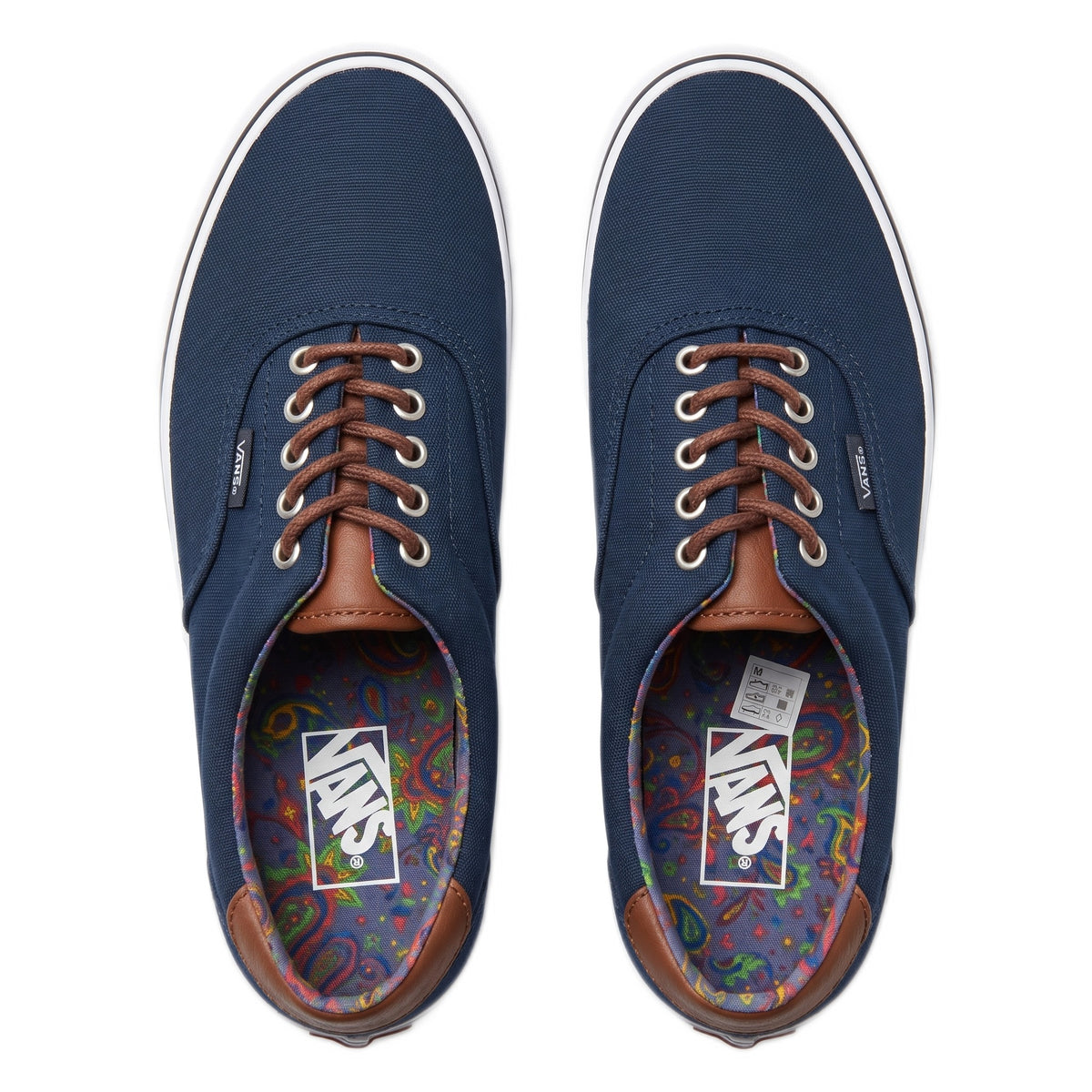 Top-down view of the pair of navy Vans shoes with brown laces and paisley insoles.