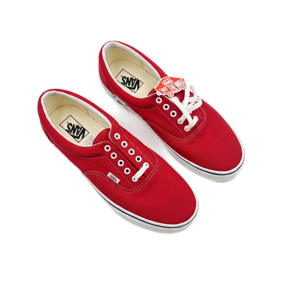Three-quarter view of pair of red low-top sneakers with white laces.