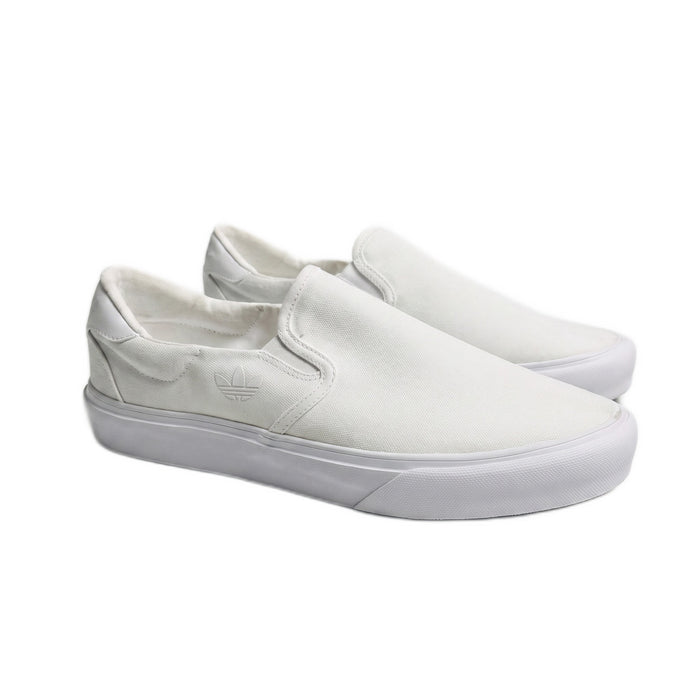 Three-quarter view of both white canvas slip-on sneakers on a white background.