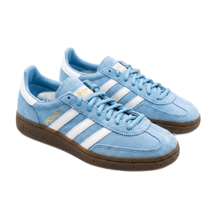 Three-quarter view of a pair of light blue suede sneakers with white stripes and gum soles.