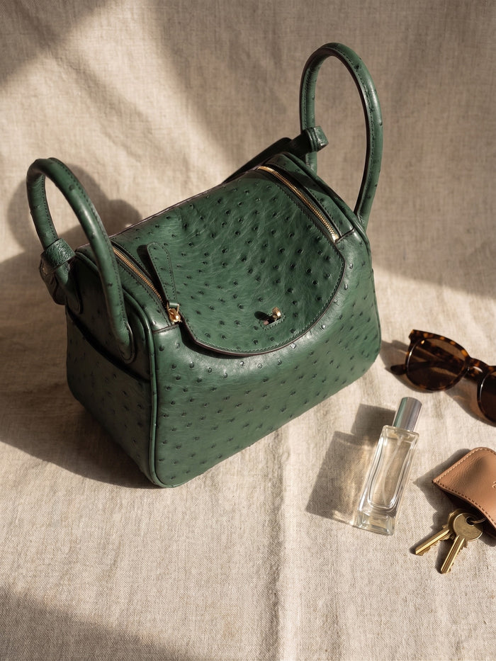 Styled on linen with sunglasses, a fragrance bottle and keys