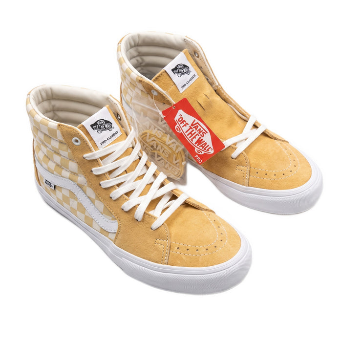 Three-quarter view of yellow checkerboard high-top sneakers with white laces.