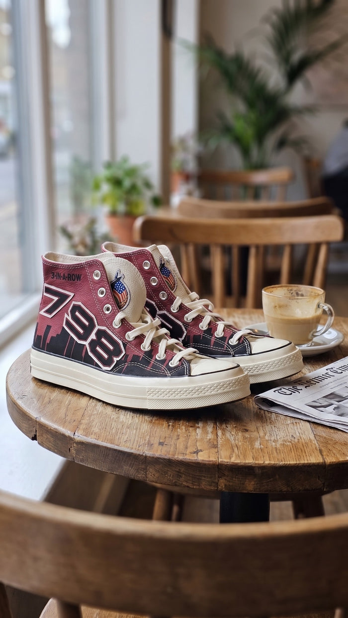 Both sneakers displayed on a wooden round table next to a coffee cup.