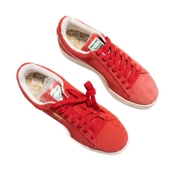 Three-quarter top-down view of both red suede sneakers on a white background.