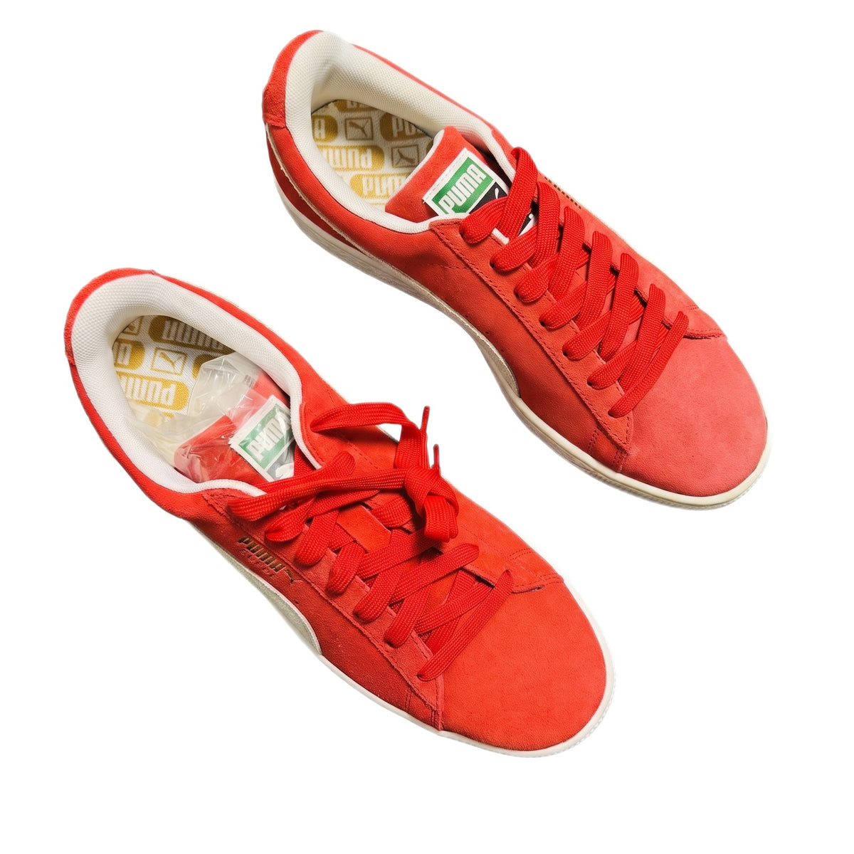 Top-down view of both red suede sneakers showing the gold-printed insoles.