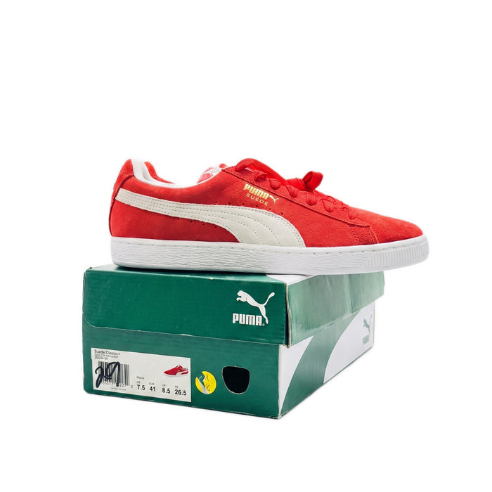 Side profile of one red sneaker sitting on top of a green Puma shoebox.