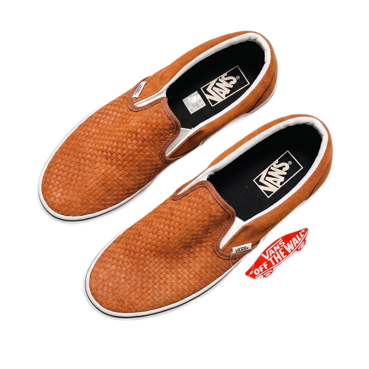 Top-down view of brown embossed suede slip-on shoes.