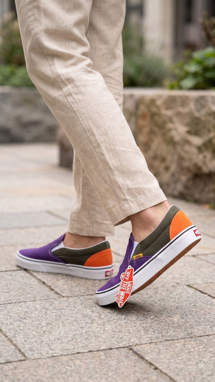 Worn view of the shoes on-foot, paired with light trousers on a paved outdoor path.