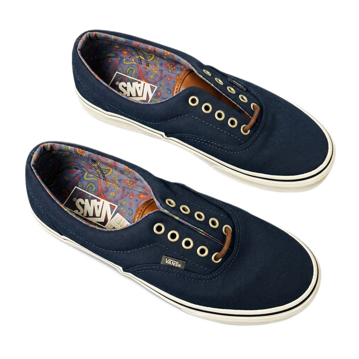 Three-quarter view of both navy Vans shoes without laces, showing paisley lining.