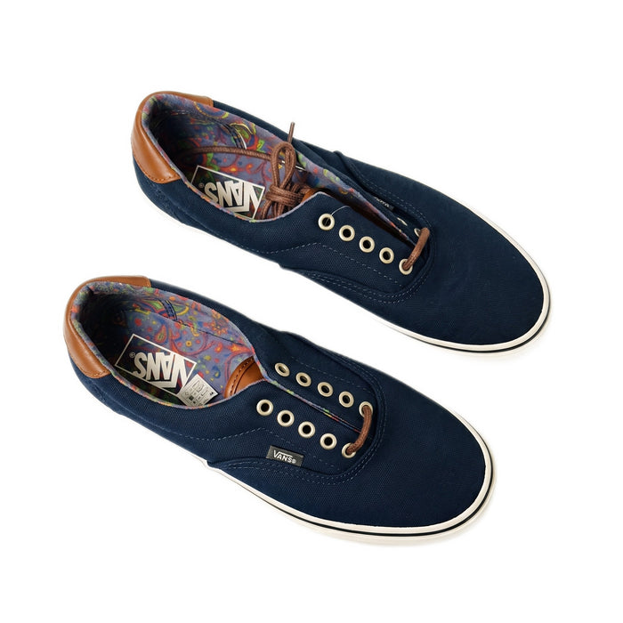 Three-quarter view of navy Vans shoes with leather laces loosely laced.